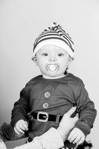 穿着圣诞精灵服装的男孩在圣诞树附近的婴儿