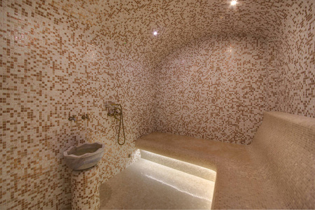 粗人从一个大理石水槽和淋浴的小轻质瓷砖