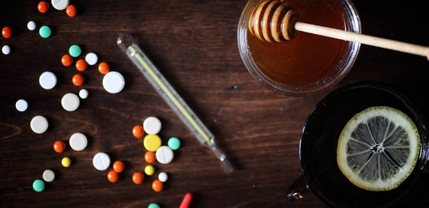 在木桌上的药物和药片。各种防止感冒的方法