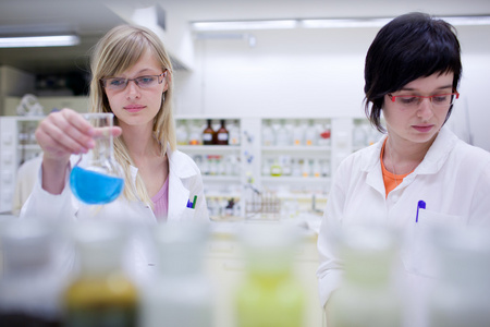 两名女性研究人员在化学实验室进行研究