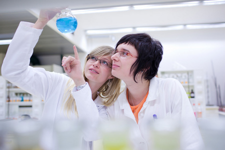 两名女性研究人员在化学实验室进行研究