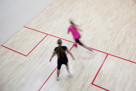两名女子壁球运动员在壁球场上的快速动作