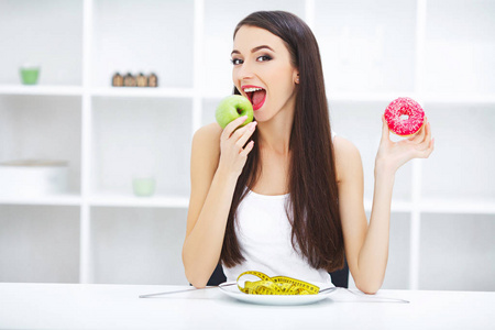 节食概念, 美丽的少妇选择在健康之间