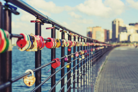 蜜月的彩色锁悬挂在河堤的栏杆上