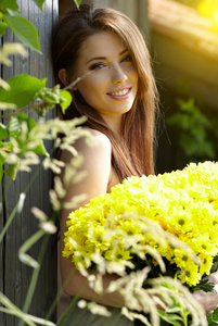 漂亮的女人在花园里放松。 捧着黄色的花朵