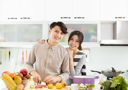 快乐的年轻夫妇在厨房做饭