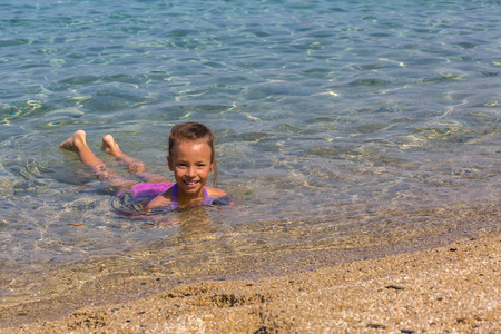 年轻的旅游女孩在爱琴海的 Sithonia 半岛海岸游泳