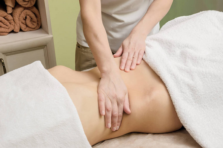 在沙龙中放松对女性腹部的专业按摩照片