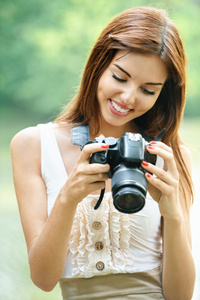 年轻漂亮的黑发女人控股 photocamera 的肖像