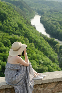 女孩坐在山上, 拍摄的背景下的森林和河流