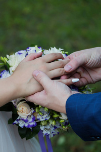 新郎把戒指放在新娘手上。照片特写