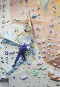 年轻女子练习攀岩岩壁在室内