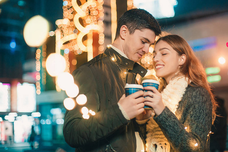 圣诞节的时候, 年轻的情侣在夜晚的街道上亲吻和拥抱