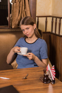 现代咖啡店年轻女学生的肖像咖啡杯