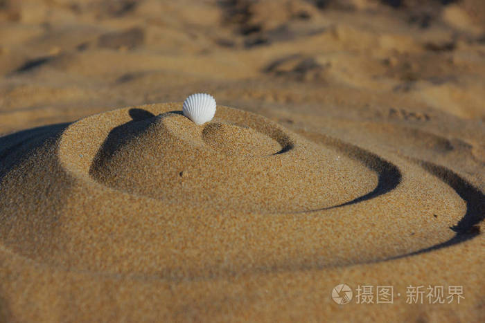 图金字塔的卷发上松散的温暖的沙子 白色的壳顶部
