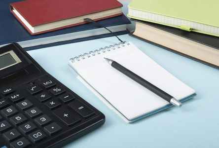 家庭储蓄, 预算概念。木制办公桌桌上的记事本钢笔计算器