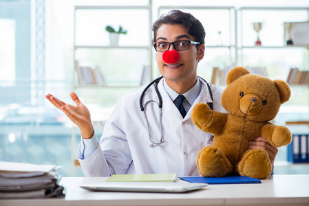滑稽的儿科医生与玩具在医院诊所