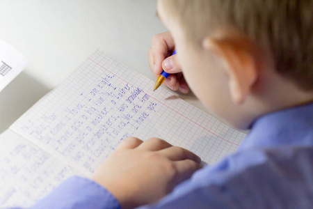 用铅笔在传统的白色记事本纸上手工书写英语单词的特写