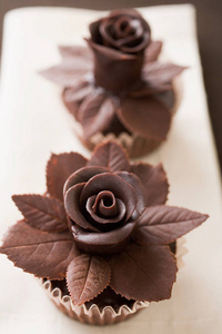 用巧克力玫瑰装饰的两块蛋糕