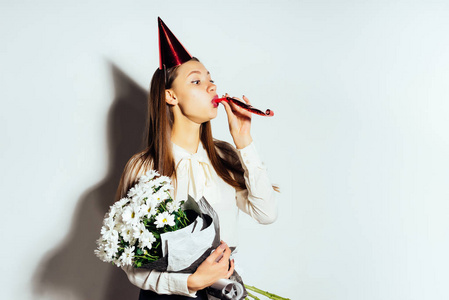 一个年轻的女孩抱着一大束白花，红色的喜庆盖在她头上，庆祝东西