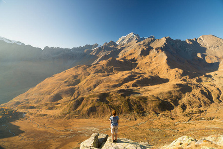 一个人看着阿尔卑斯山的高处观。南昆线膨胀山水 田园看日落。后视图