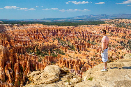 在美国犹他州布莱斯峡谷国家公园, 站在美丽的红砂岩石林美景的年轻人