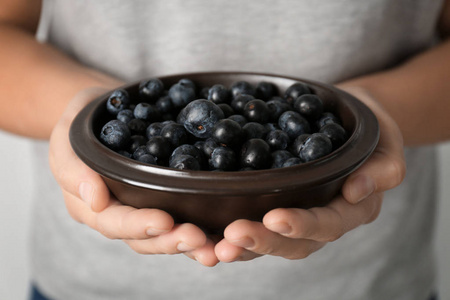 女人抱着碗新鲜 acai 浆果，特写