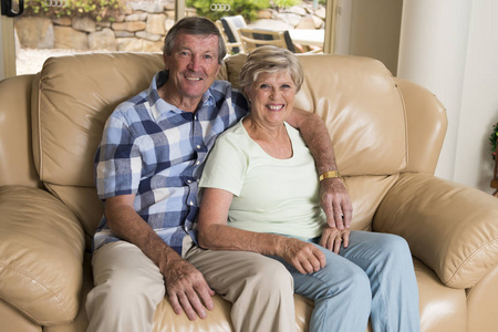 年长的美丽中年夫妇在70岁左右笑开心一起在家里客厅沙发沙发看起来甜美的一生的爱