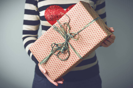 女孩抱着一份圣诞礼物包装盒