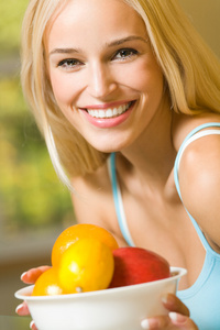 年轻快乐微笑的女人的肖像，带着一盘水果