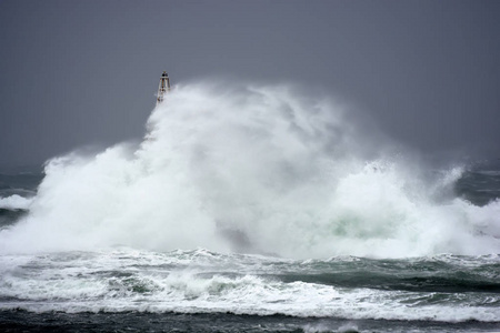 浪对老灯塔在 Ahtopol , 黑海的口岸 , 保加利亚在一个暴风雨的天