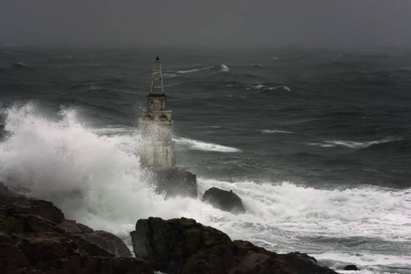 浪对老灯塔在 Ahtopol , 黑海的口岸 , 保加利亚在一个暴风雨的天