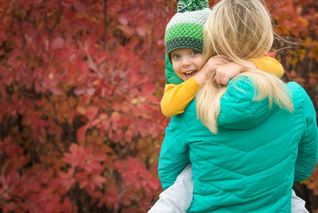 母亲和小儿子在秋季公园散步. 温柔的拥抱