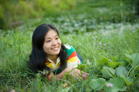 微笑的女人躺在草地上