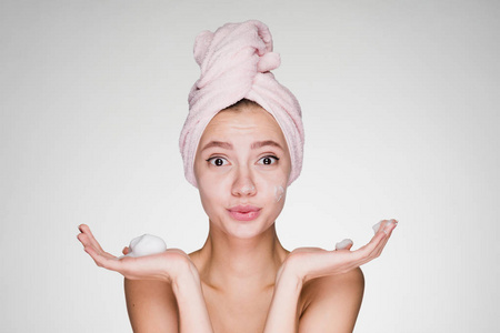 女孩洗完澡, 头上拿着一条毛巾, 双手捧着泡沫