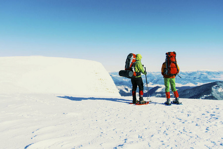 冬天在山上徒步旅行, 两个人沿着雪地漫步