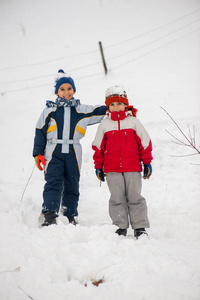 顽皮欢快的孩子在雪地里滑雪橇和雪人