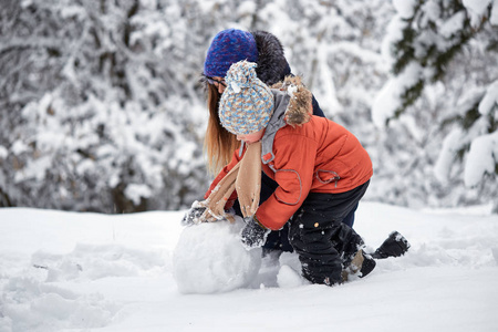 冬天的乐趣。一个女孩和一个男孩在做雪球