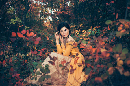 一个脆弱的, 温柔的女孩在黄色的复古礼服漫步的背景下, 火热的秋季自然。艺术摄影