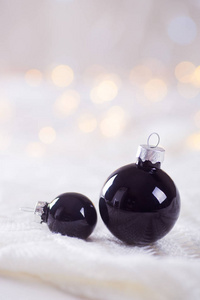 两个黑色白色花边上光和温暖的散景的圣诞球