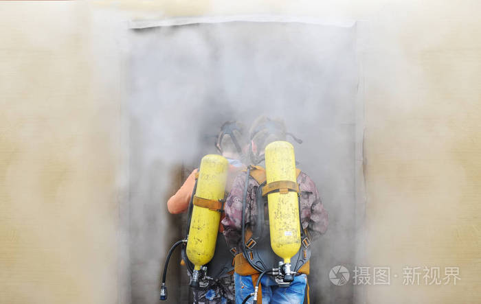 两名消防员在防护罩内配备氧气瓶 去烟雾室