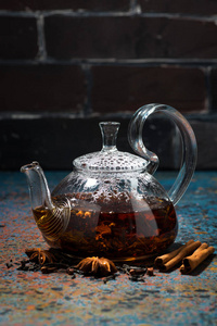 茶马萨拉在一个玻璃茶壶在黑暗的背景下, 垂直