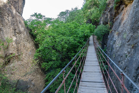 岩石之间峡谷中的铁和木吊桥