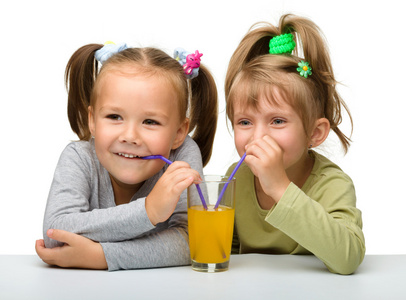 两个小女孩在喝橙汁