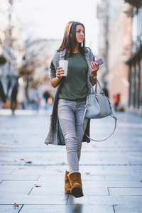 女孩 takeaway 咖啡在城市寻找 storesand 购物