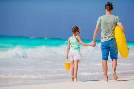在热带海滩的父亲和小女孩的家庭