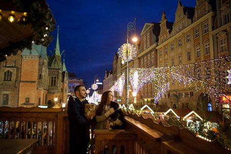 圣诞节.年轻的情侣从阳台上欣赏节日的城市