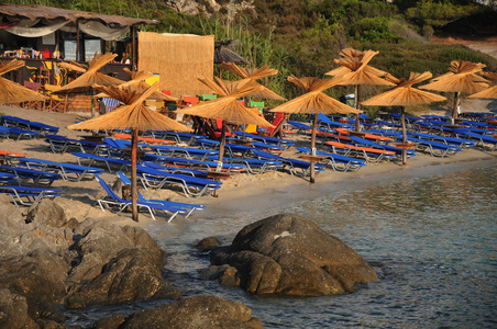 希腊白沙和石头海滩，有咖啡馆和海滩伞形花序