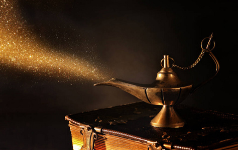 图像的神奇阿拉丁灯带金色亮片烟。灯的愿望