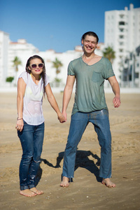 欢快的年轻夫妇在沙滩上湿衣服的费用